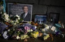 Floral tributes and pictures of British Member of Parliament David Amess lie placed outside the Houses of Parliament in London, Oct. 20, 2021.