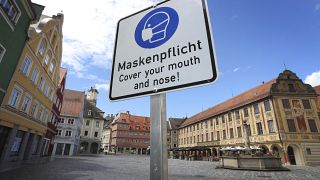 A sign on the town hall square points out that masks are mandatory in Memminhgen.