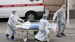 Medical staff members push a cart out of the COVID-19 infection department in a city clinic in Kyiv, Ukraine, Thursday, Oct. 21, 2021.