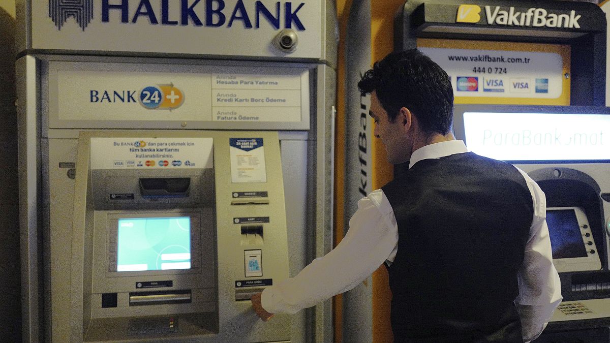 رجل يسحب أموالاً من جهاز صراف آلي تابع لبنك تركي في أنقرة.
