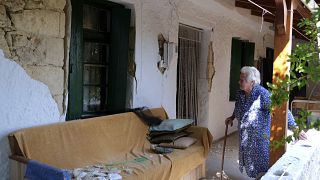Idős asszony nézi földrengéstől megrongálódott házát Archontiko faluban 2021. szeptember 28-án