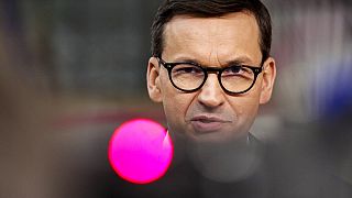 Poland's Prime Minister Mateusz Morawiecki talks to journalists as he arrives for an EU summit in Brussels, Thursday, Oct. 21, 2021