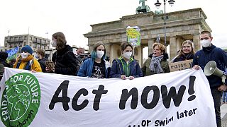 Demonstrat:innen stehen vor dem Brandenburger Tor im Rahmen einer "Fridays For Future"-Klimakundgebung in Berlin, Deutschland, Freitag, 22. Oktober 2021.