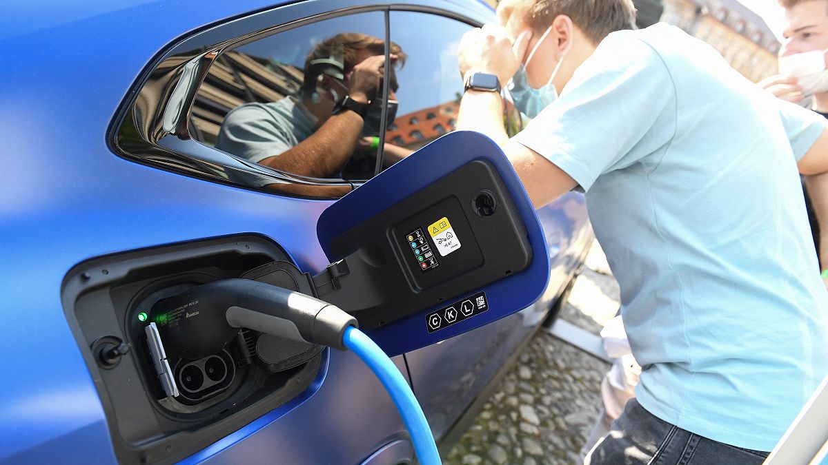 Visitors take a look at an electric car at the stand of German car maker BMW at the Max-Joseph-Platz square in Munich, southern Germany,