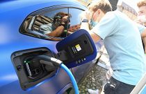 Visitors take a look at an electric car at the stand of German car maker BMW at the Max-Joseph-Platz square in Munich, southern Germany,
