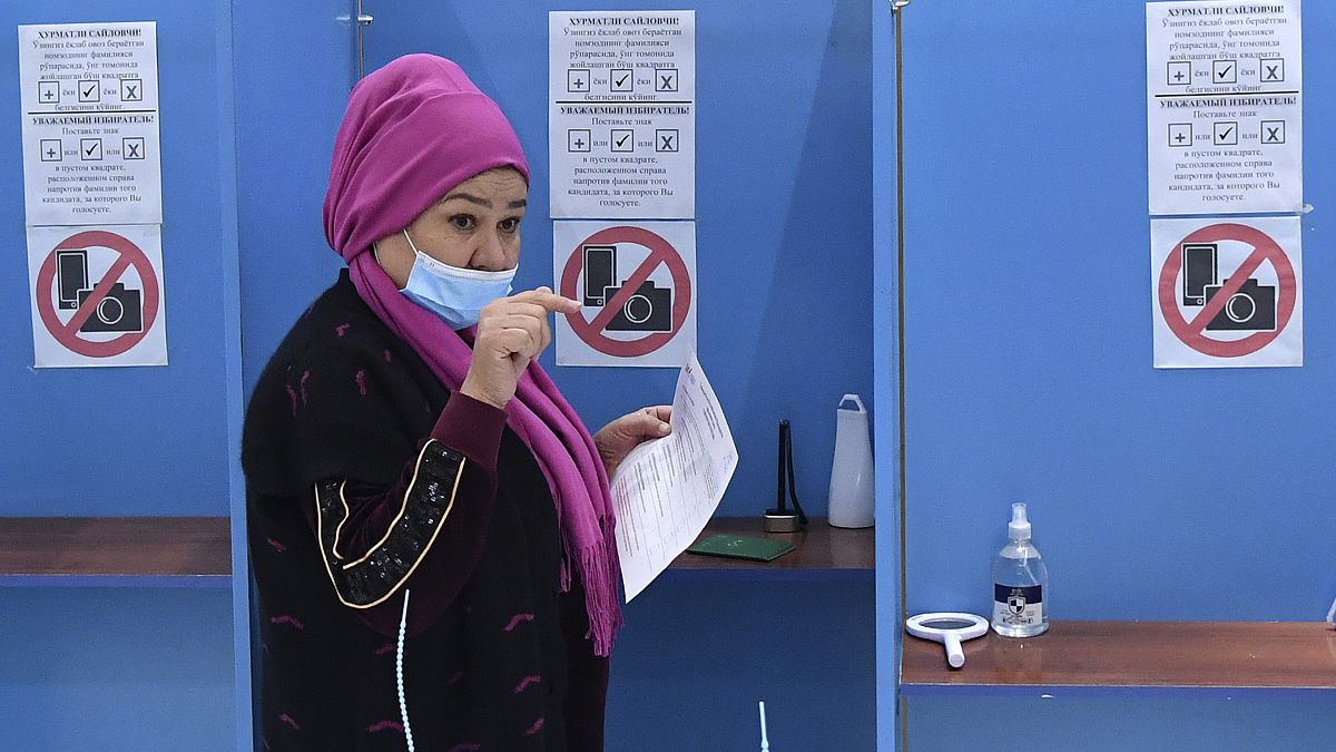 A woman walks to cast her ballot at a polling station during the presidential election in Tashkent, Uzbekistan, Sunday, Oct. 24, 2021. 