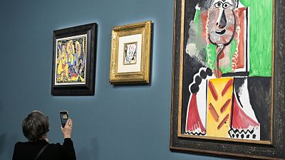 An auction attendee photographs one of the 11 Picasso paintings up for grabs