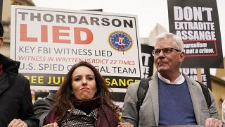 Julian Assange's partner Stella Morris, left, and Wikileaks editor-in-chief Kristin Hrafnsson hold placards and take part in a march in London, Saturday, Oct. 23, 2021