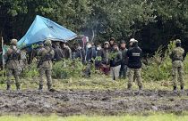 In this Sept. 1, 2021 file photo, Polish security forces block migrants stuck on the border with Belarus in Usnarz Gorny, Poland.