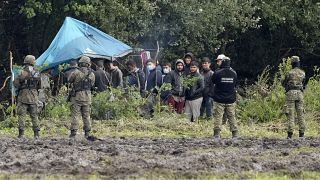 In this Sept. 1, 2021 file photo, Polish security forces block migrants stuck on the border with Belarus in Usnarz Gorny, Poland.