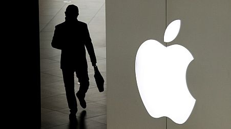 In this Jan. 3, 2019, file photo, a man leaves an Apple store in Beijing, China.