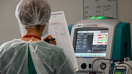 A nurse notes the medical data of a Covid-19 patient at the Pasteur hospital resuscitation unit in Colmar, eastern France, on January 22, 2021.