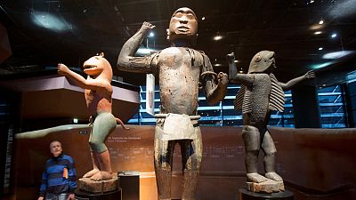 A visitor looks at wooden royal statues of the Dahomey kingdom, dated 19th century, at Quai Branly museum in Paris, France, 2018.