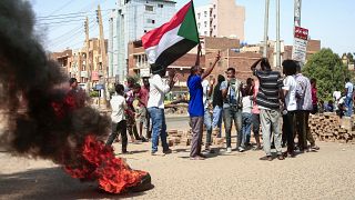 Manifestantes sudaneses queimam pneus numa rua da capital Cartum, 26 de outubro de 2021
