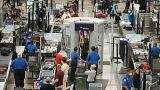 Travellers wear face coverings in the line for the south security checkpoint in the main terminal of Denver International Airport on Aug. 24, 2021, in Denver. 