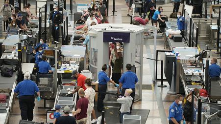 Travellers wear face coverings in the line for the south security checkpoint in the main terminal of Denver International Airport on Aug. 24, 2021, in Denver.