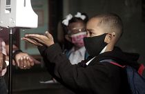 Children and their parents and caretakers line up to return to classes