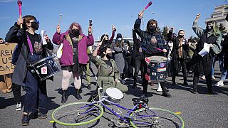 FILE: Women take part in rally during International Women's Day outside the government headquarters in Bucharest, Romania, Monday, March 8, 2021