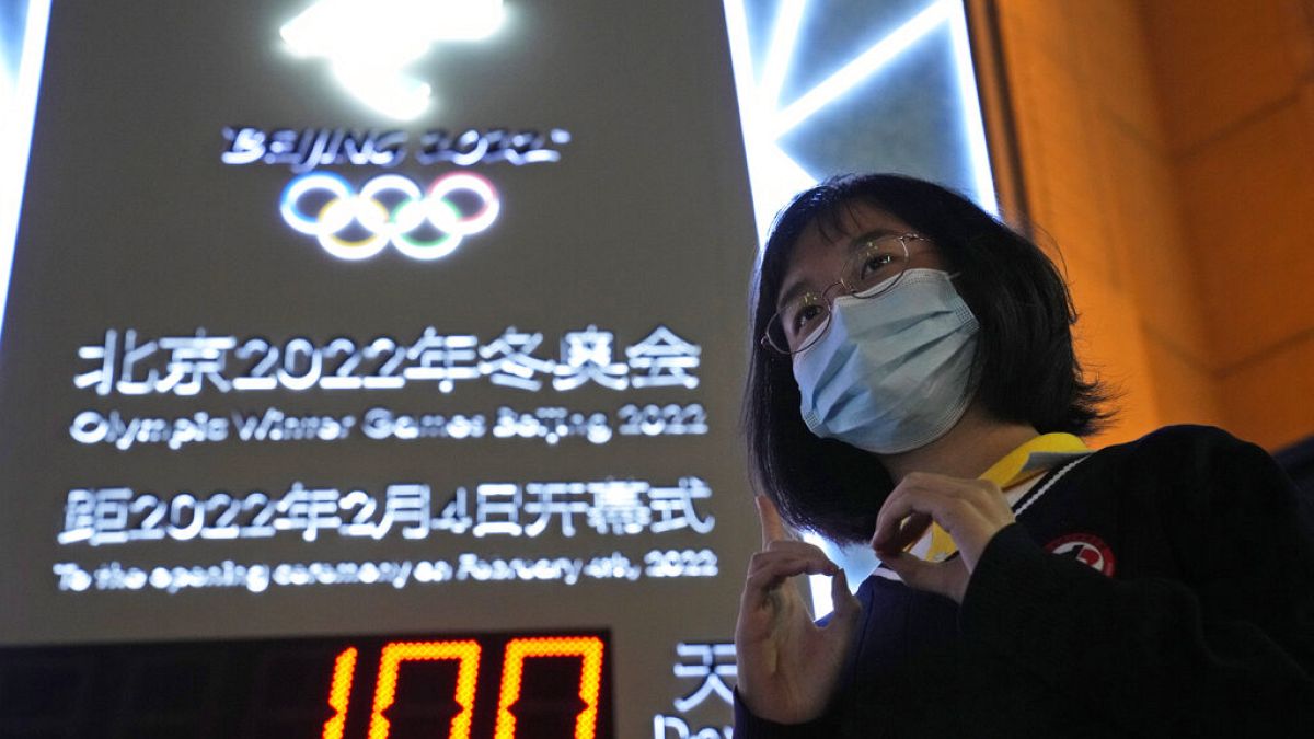 Una donna di fronte al countdown per Pechino 2022