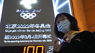 Una donna di fronte al countdown per Pechino 2022