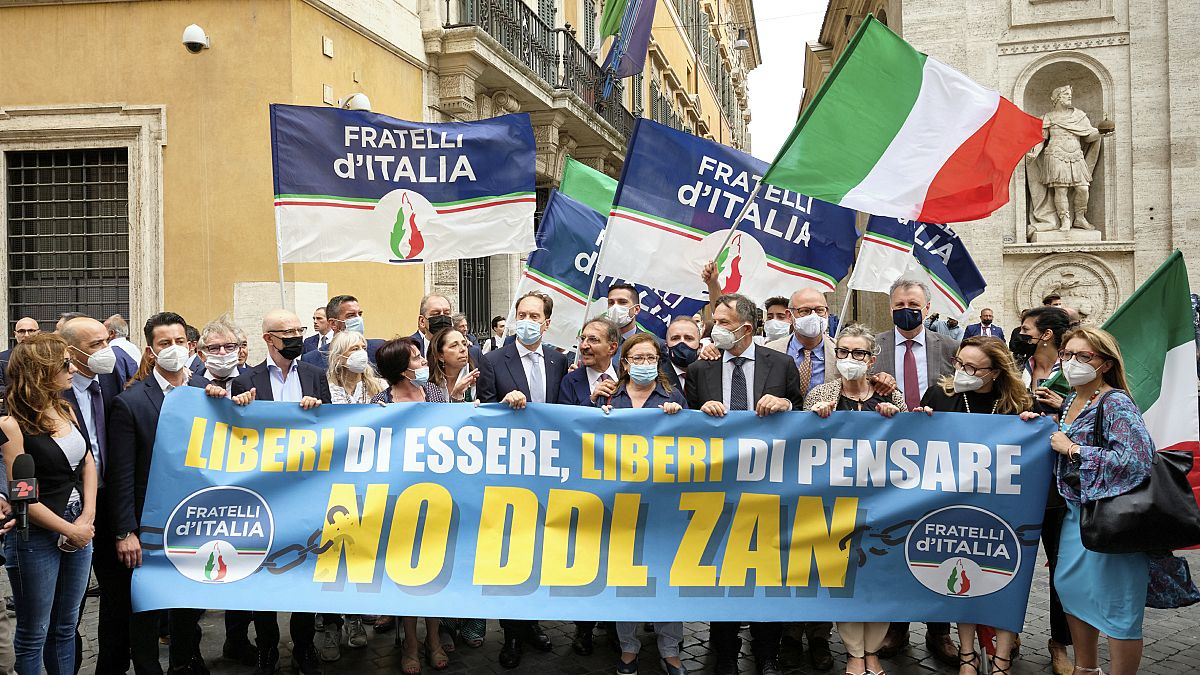 Right wing party, Brother of Italy lawmakers hold a banner reading: free to be, free of thinking, NO to Zan law" as they protest outside the Italian Senate, July 2021.