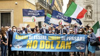 Right wing party, Brother of Italy lawmakers hold a banner reading: free to be, free of thinking, NO to Zan law" as they protest outside the Italian Senate, July 2021.