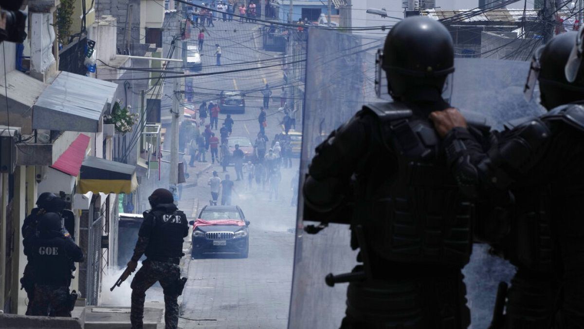La policía observa a los manifestantes retirarse, en Quito, tras lanzarles gases lacrimógenos, en el segundo día de protestas en Ecuador. 