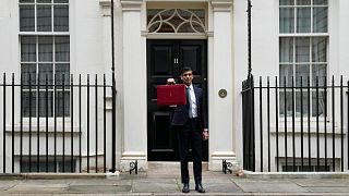Britain's Chancellor of the Exchequer Rishi Sunak holds up the traditional ministerial red dispatch box as he leaves for the House of Commons to deliver the Budget in London.