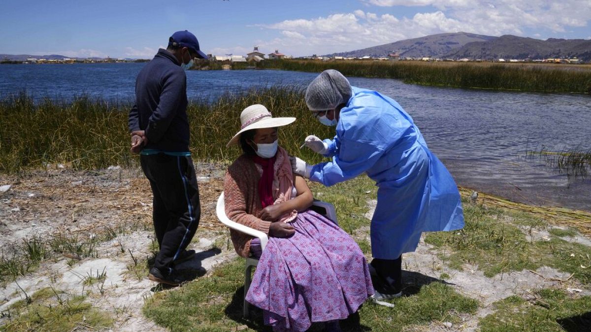 Une infirmière vaccine contre le Covid-19 une habitante du lac Titicaca.