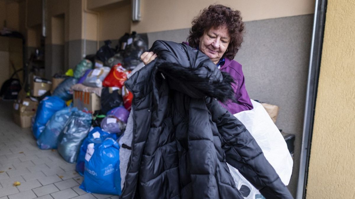 Krystyna Luczewska carries a winter coat as she came to give warm clothes to migrants at the help center in Michalowo Poland, on October 22, 2021.