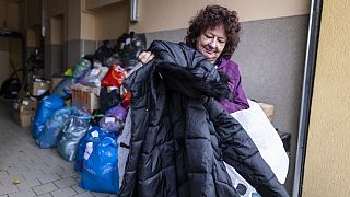 Krystyna Luczewska carries a winter coat as she came to give warm clothes to migrants at the help center in Michalowo Poland, on October 22, 2021.