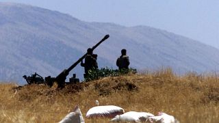 جنود سوريون يجهزون مضاداً للطائرات بالقرب من الحدود اللبنانية 