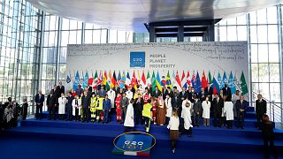 Medical personnel walk onto the stage for a group photo with world leaders at the La Nuvola conference center for the G20 summit in Rome, Saturday, Oct. 30, 2021. 