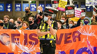 Klímaaktivisták transzparenseket tartanak a skóciai Glasgow központi pályaudvarán a COP26 kezdete előtt, 2021. október 30-án, szombaton.