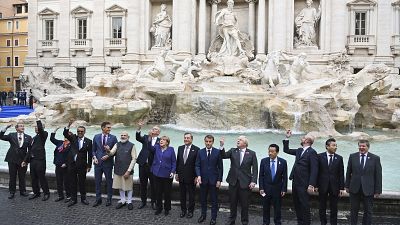 Leaders of the G20 throw coins inside the Trevi Fountain.