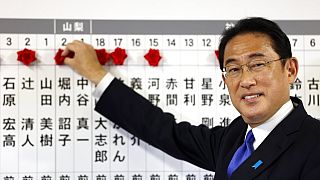 Japonya Başbakanı Kişida, Tokyo'daki parti merkezinde bir panoya başarılı genel seçim adaylarının isimlerinin rozetlerini ekliyor