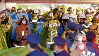 Emergency workers and police officers at the train station in Tokyo