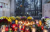Candles and flowers lay in front of the locked gate to Powazki cementary in Warsaw, Poland, on November 1, 2020.