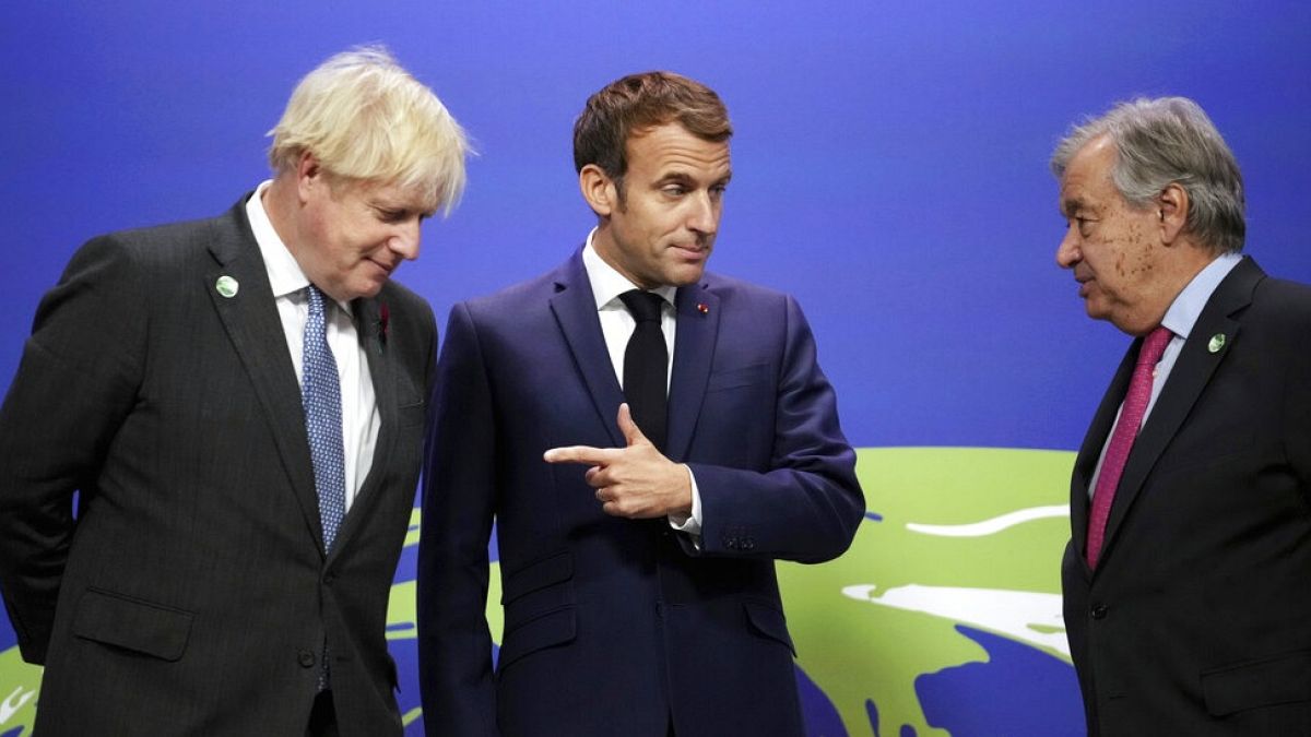 Boris Johnson, left, and UN Secretary-General Antonio Guterres, right, greet French President Emmanuel Macron, at the COP26