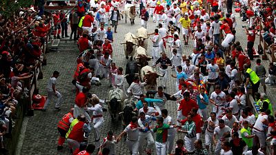 Runners sprint in front of Torrestrella fighting bulls at the during the San Fermin festival in Pamplona, Spain