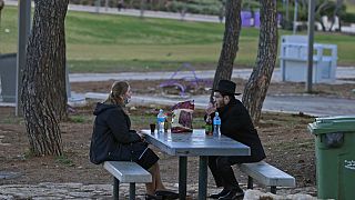 رجل يهودي وامرأة يتحدثان في حديقة عامة -  القدس. 2021