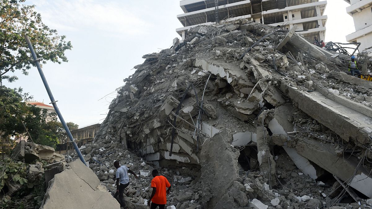 Des gens tentent de secourir des travailleurs piégés des décombres d'un immeuble construction qui s'est effondré dans le quartier d'Ikoyi à Lagos, le 1er novembre 2021.