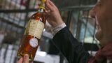 An unidentified auction goer displays a bottle of 1966 Chateau d'Yquem premier cru Sauternes put on auction by the French presidential Palace. File: May 2013