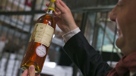 An unidentified auction goer displays a bottle of 1966 Chateau d'Yquem premier cru Sauternes put on auction by the French presidential Palace. File: May 2013