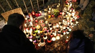 People place candles in tribute to a woman who died in the 22nd week of pregnancy, in Warsaw, Poland, Monday Nov. 1, 2021.