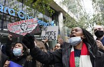 Manifestantes sostienen pancartas en una protesta contra el cambio climático frente al Standard and Chartered Bank en Londres, Reino Unido, el 29 de octubre de 2021.