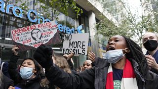 Manifestantes sostienen pancartas en una protesta contra el cambio climático frente al Standard and Chartered Bank en Londres, Reino Unido, el 29 de octubre de 2021.