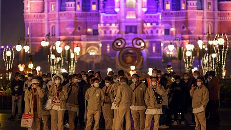 Disneyland employees gather to wait for their COVID-19 tests at the Shanghai resort on Sunday.