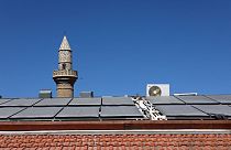 تُظهر هذه الصورة الألواح الشمسية أمام مئذنة مسجد على سطح منزل قبرصي تقليدي في قرية كالافاسوس في منطقة لارنكا، 7 أكتوبر 2021