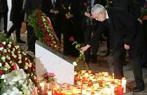 Austria's President Alexander Van der Bellen lays a flower after the memorial service in Vienna.